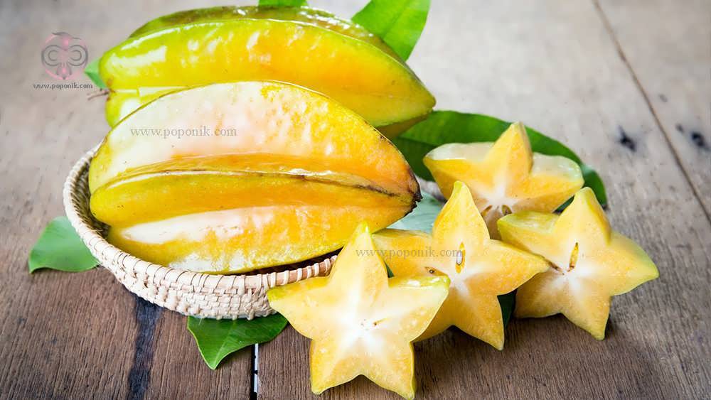 میوه پوست کنده شده ستاره کنار میوه ستاره در سبد همراه برگ های میوه ستاره